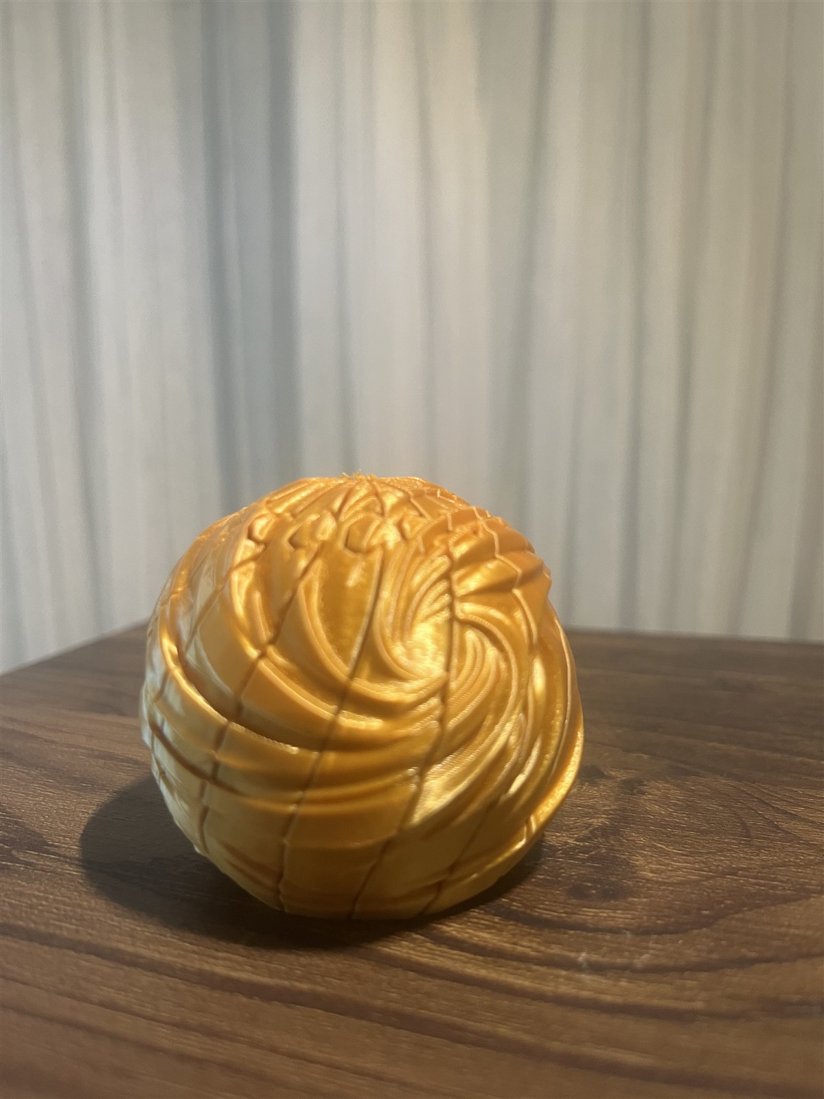 Gold Collapsible Spiral Orb Fidget in its round shape